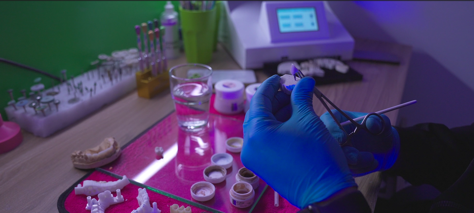 Dentist working on dental implants with tools and materials in a modern clinic.
